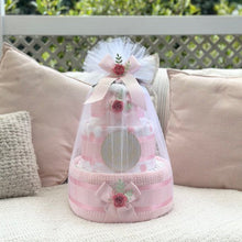 Load image into Gallery viewer, Pink diaper cake with decorative flowers on a couch outdoors